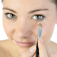 Frau benutzt Make Up gegen Augenringe