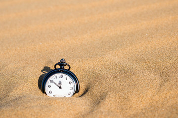 Pocket watch buried in sand