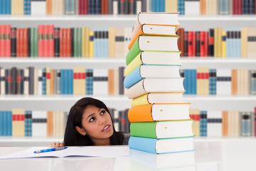 Woman Looking At Stack Of Books