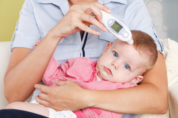 Baby with a digital thermometer