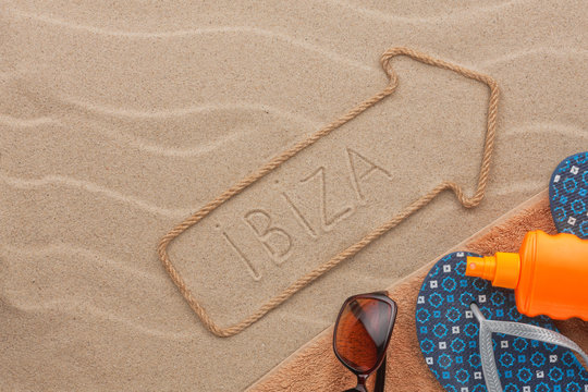 Ibiza pointer and beach accessories lying on the sand