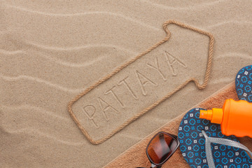 Pattaya  pointer and beach accessories lying on the sand