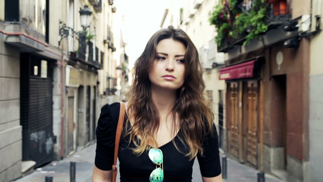 Sad, pensive beautiful woman walking in the city