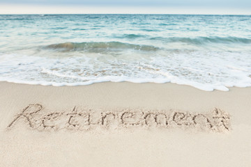 Fototapeta na wymiar Retirement Written On Sand By Sea