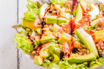 Avocado salad with fried bacon and pine nuts