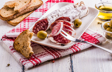 Slices of salami on a white plate