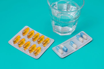 Water glass and medicaments on turquoise