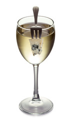 Cheese on a fork and glass with white wine
