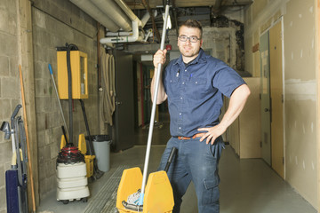 A serviceman who cleaning the floor with his mop