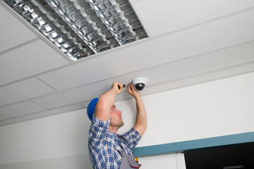 Technician Fixing Security Camera