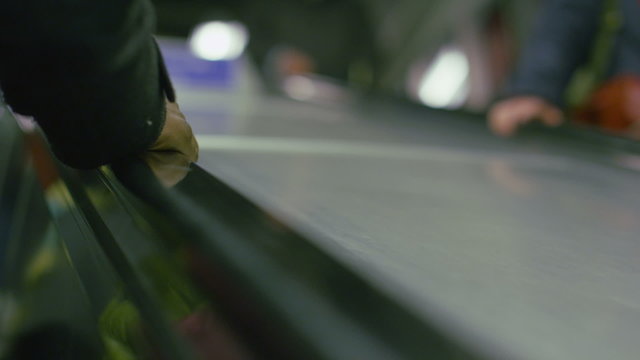 Slow motion clip of mans hand on escalator going up