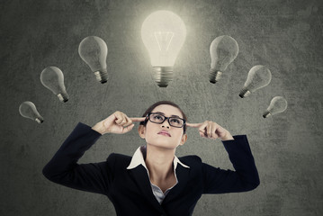 Female manager thinking idea under lightbulbs