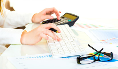 Fototapeta premium Woman with beautiful hands working on the calculator and keyboar