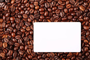 Against the backdrop of coffee beans is a business card