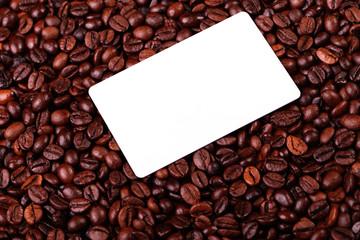 Against the backdrop of coffee beans is a business card