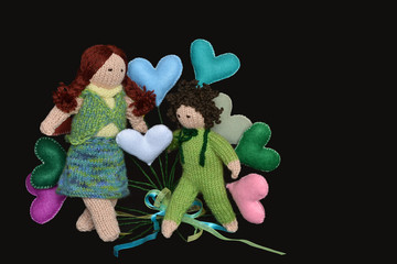 Handmade dolls, mother and child playing with coloured hearts