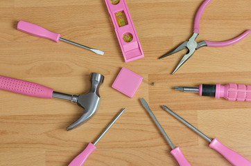 top view of pink handyman tools on wooden table