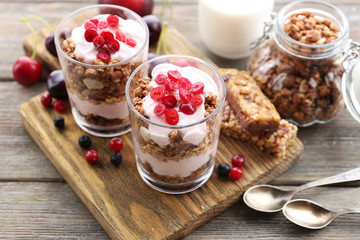 Healthy layered dessert with muesli and berries on table