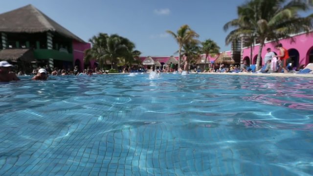 Reflection of Sun in Pool Water. Unrecognizable people around