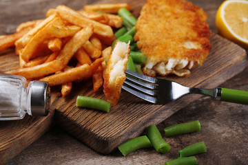 Breaded fried fish fillet and potatoes with asparagus