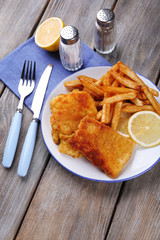 Breaded fried fish fillets and potatoes with with sliced lemon