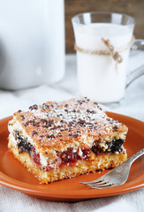 Homemade pie with jam and glass and can of milk