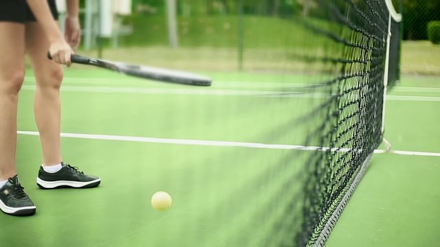 Unrecognizable Female Bouncing a Tennis Ball inside the Court