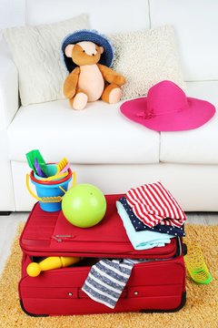 Suitcase packed with clothes and child toys