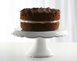 Delicious chocolate cake on table on light background