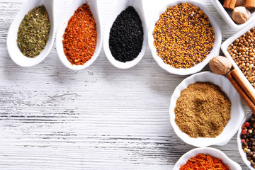 Different kinds of spices in ceramics bowls and spoons