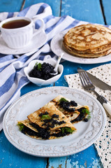 A stack of pancakes with black caviar