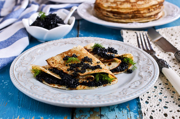A stack of pancakes with black caviar