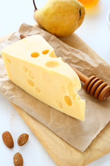 Cheese with almonds and pear on a cutting board
