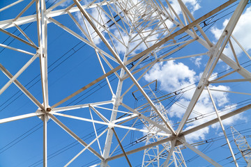Bottom view power transmission lines against blue sky