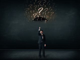 Businessman with umbrella and a lot of drawn question marks