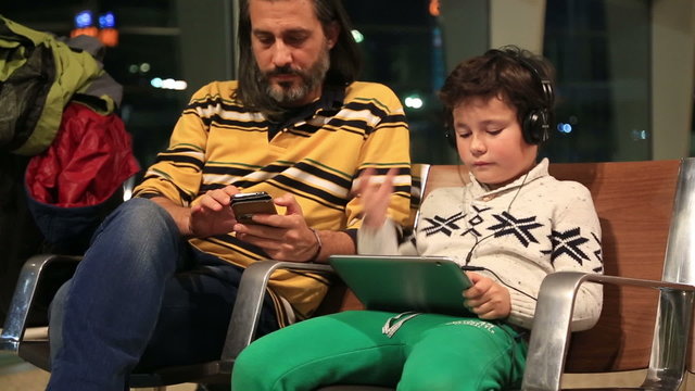 Father and son waiting at the airport