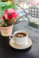 coffee in white cup with flowers background