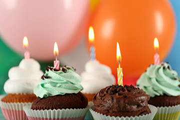 Delicious birthday cupcakes on bright background