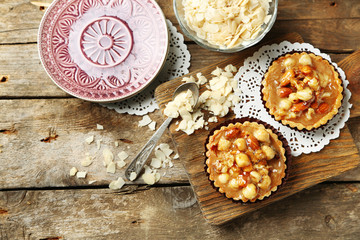 Mini cakes with nuts on wooden background