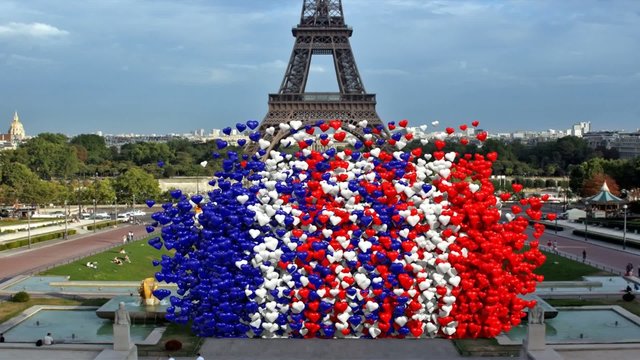 Cuori colore Francia si alzano con sfondo Eiffel