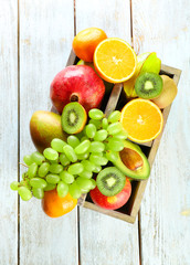 Assortment of fruits in box on wooden table