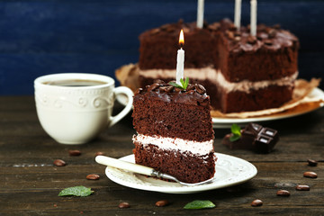 Delicious chocolate cake on table on blue background