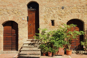 picturesque old wall with doors in tuscan village Pienza, Italy
