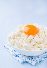 Cottage cheese with egg yolk in white bowl