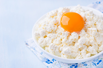 Cottage cheese with egg yolk in white bowl