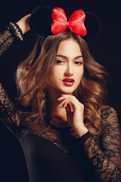 Portrait of a beautiful model with a red bow on a dark backgroun