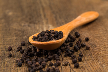 black pepper on wooden spoon