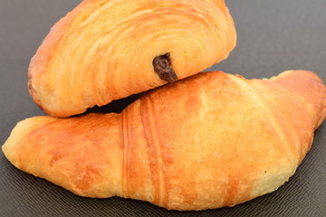 Two fresh croissants.on a black background.
