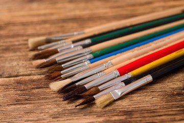 Obraz premium Collection of different paintbrushes on wooden board