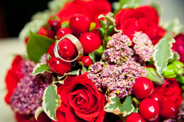 two wedding rings lie on a bouquet